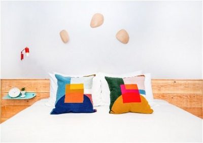 A bed with two pillows that are colorful